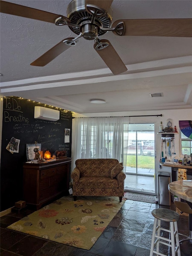 living room with ceiling fan and a wall unit AC