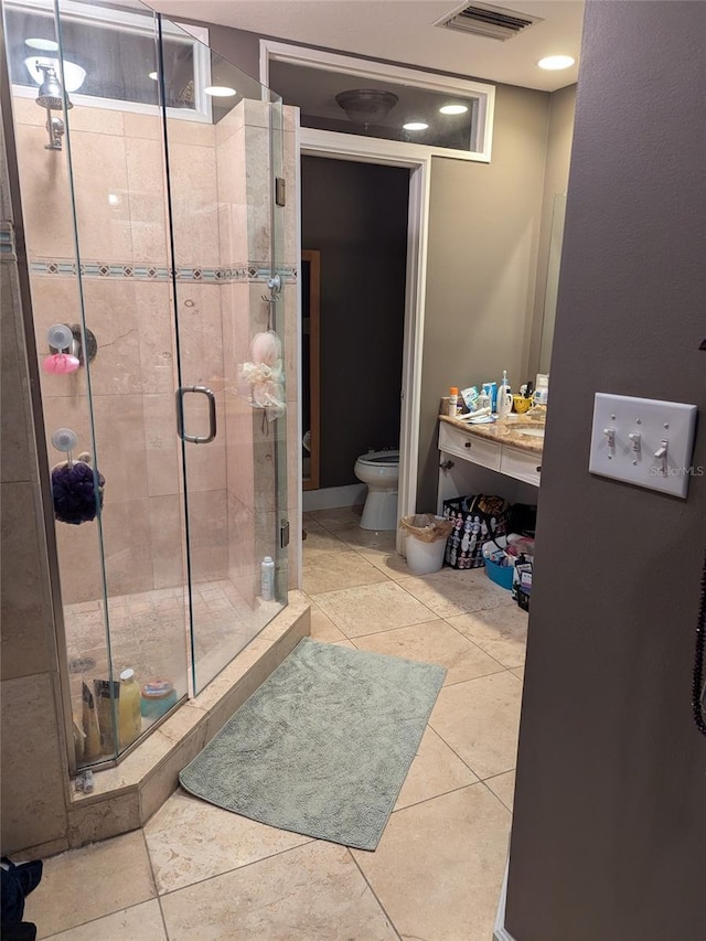 bathroom with an enclosed shower, tile patterned floors, and toilet