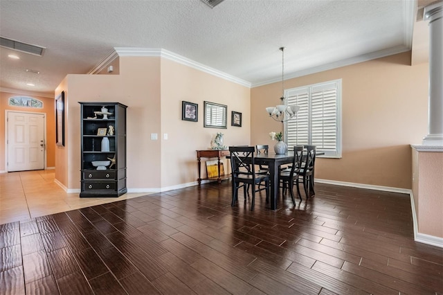 dining area featuring crown molding, a textured ceiling, visible vents, and wood finished floors