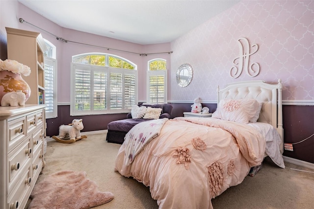 bedroom featuring light carpet, baseboards, and wallpapered walls