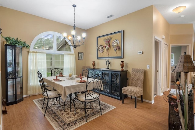 dining space with an inviting chandelier and light wood-type flooring