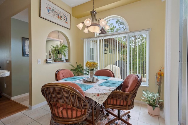 dining space with an inviting chandelier, a healthy amount of sunlight, and light tile patterned flooring