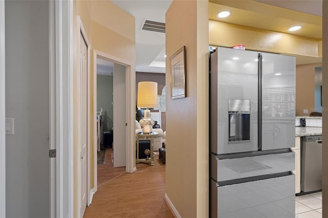 interior space with stainless steel appliances, light tile patterned floors, and light stone counters