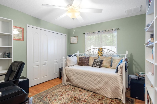 bedroom with wood-type flooring, a closet, and ceiling fan