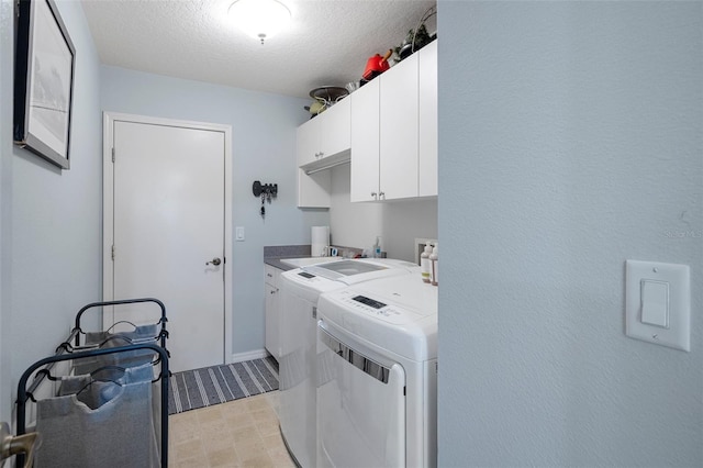 laundry room featuring cabinets, separate washer and dryer, and a textured ceiling