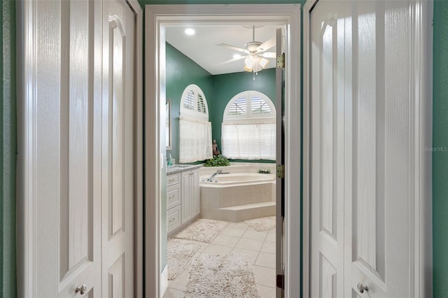 bathroom with vanity, tile patterned floors, tiled bath, and ceiling fan