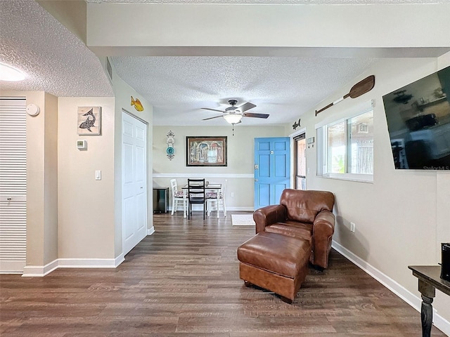 sitting room with ceiling fan, wood-type flooring, and a textured ceiling