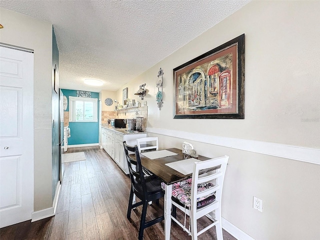 dining room with dark hardwood / wood-style floors and a textured ceiling