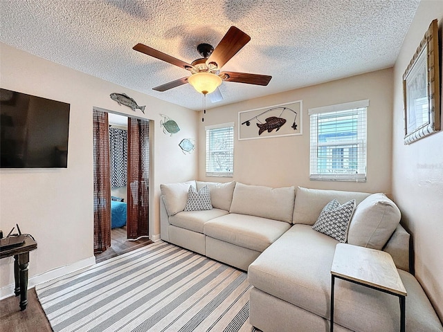 living room with a textured ceiling and ceiling fan