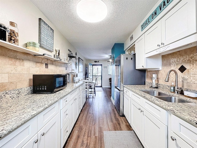 kitchen featuring sink, white cabinetry, backsplash, light stone counters, and dark hardwood / wood-style flooring