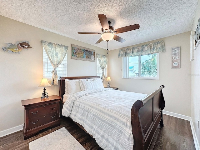 bedroom with ceiling fan, dark hardwood / wood-style flooring, and a textured ceiling