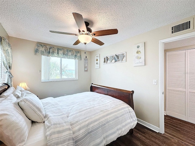 bedroom featuring ceiling fan, dark wood-type flooring, and a textured ceiling