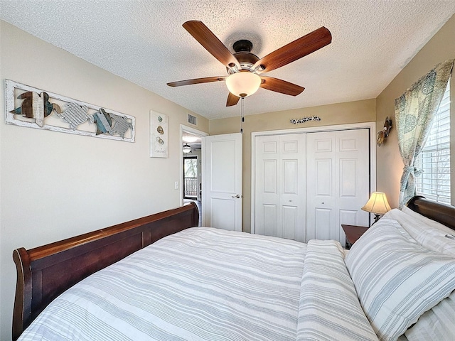 bedroom with ceiling fan, a closet, and a textured ceiling