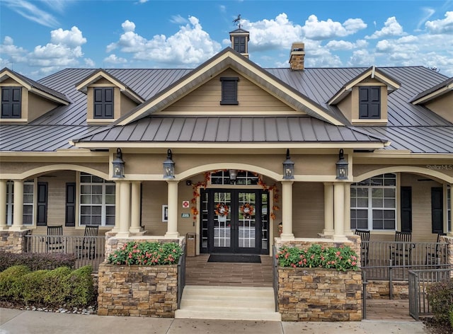 exterior space featuring covered porch, metal roof, french doors, and a standing seam roof