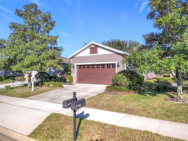 view of front facade with concrete driveway, an attached garage, a front lawn, and stucco siding