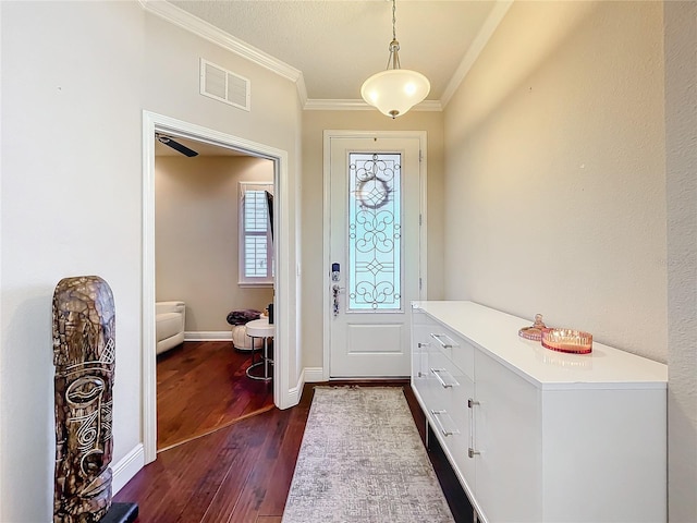 entrance foyer featuring ornamental molding, dark wood finished floors, visible vents, and baseboards