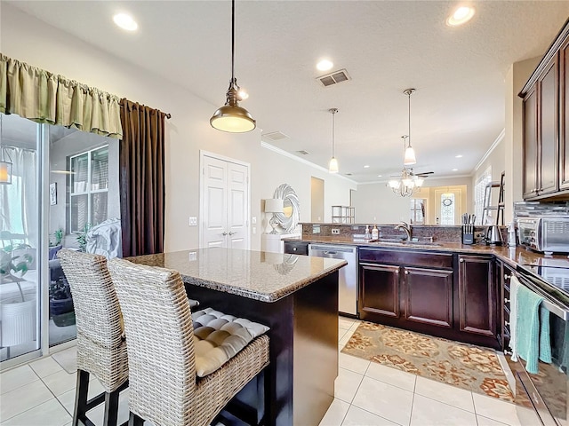 kitchen with stainless steel appliances, a breakfast bar area, a peninsula, and a sink