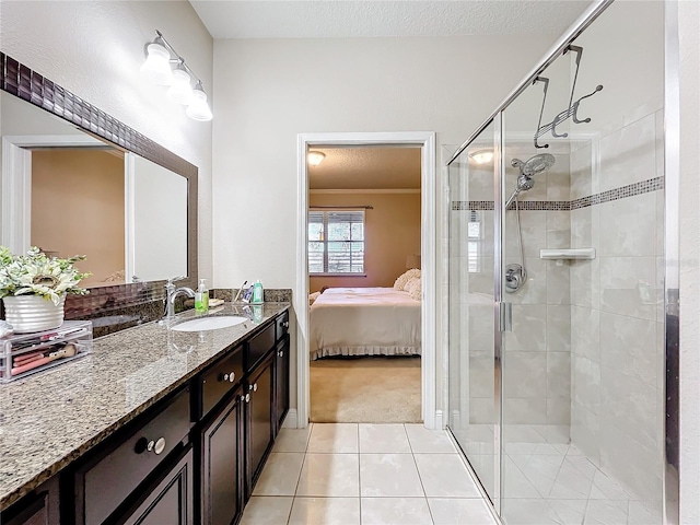 bathroom with a textured ceiling, vanity, a shower stall, tile patterned floors, and ensuite bath