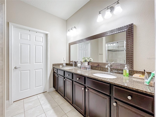 bathroom with double vanity, tile patterned floors, a sink, and a shower stall