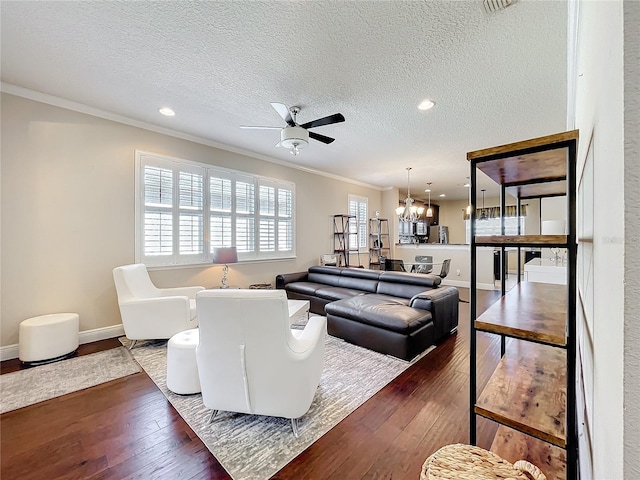 living room with baseboards, a textured ceiling, ornamental molding, and dark wood-style flooring