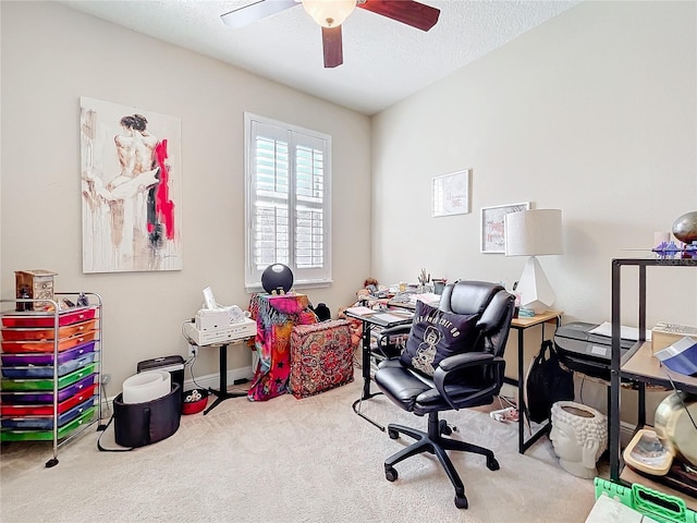 home office featuring light carpet, ceiling fan, and a textured ceiling