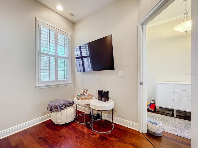 living area with baseboards and wood finished floors