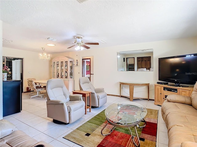 living room featuring ceiling fan with notable chandelier, a textured ceiling, and light tile patterned flooring