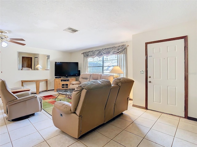 living room with light tile patterned floors, a textured ceiling, and ceiling fan