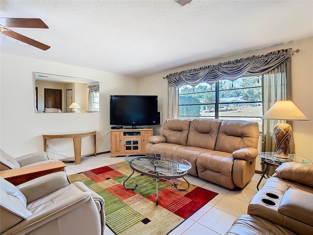 living room with ceiling fan, light tile patterned floors, and a textured ceiling