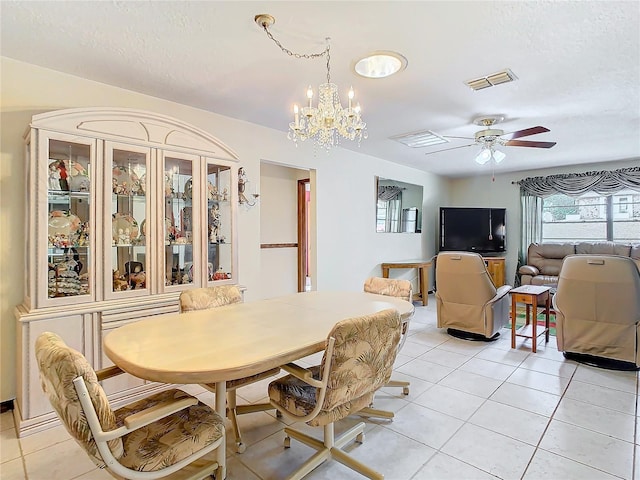 dining space with ceiling fan with notable chandelier, a textured ceiling, and light tile patterned flooring