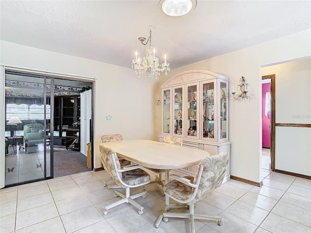 tiled dining room with a chandelier