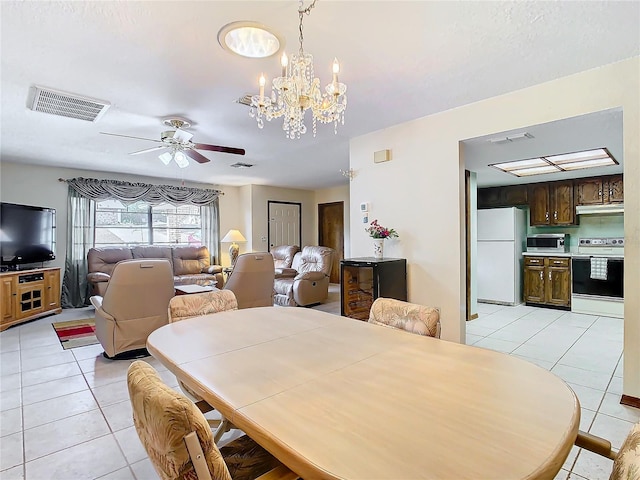 tiled dining area featuring ceiling fan with notable chandelier