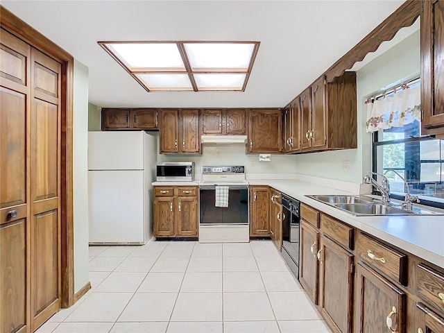 kitchen with light tile patterned flooring, sink, and white appliances