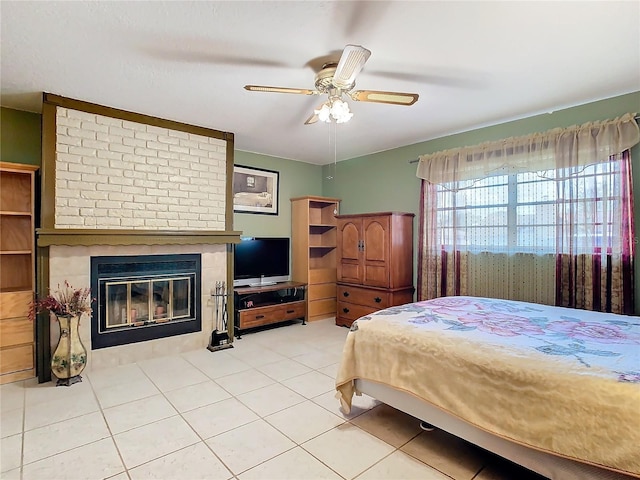 bedroom featuring ceiling fan, light tile patterned floors, and a fireplace