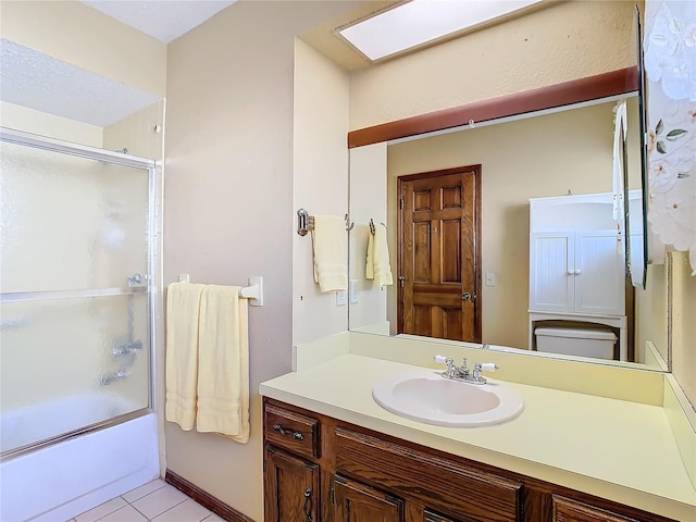 full bathroom with toilet, combined bath / shower with glass door, a skylight, vanity, and tile patterned flooring