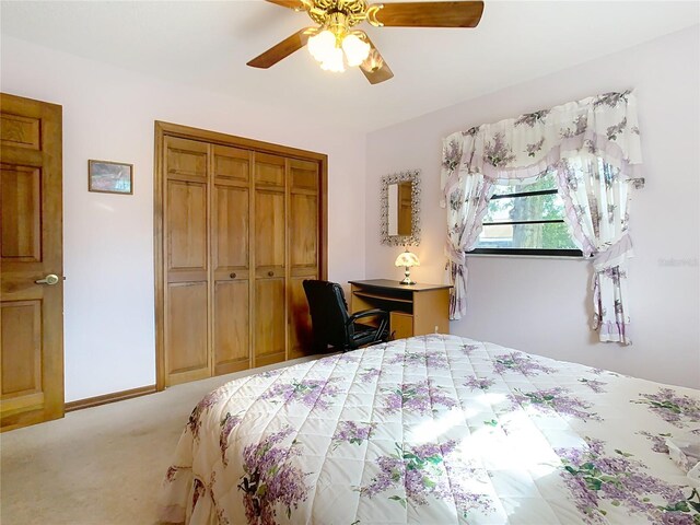 carpeted bedroom featuring ceiling fan and a closet