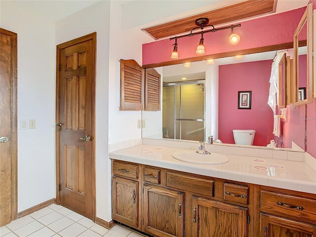 bathroom featuring vanity, tile patterned floors, toilet, and walk in shower