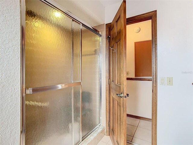 bathroom featuring walk in shower and tile patterned flooring