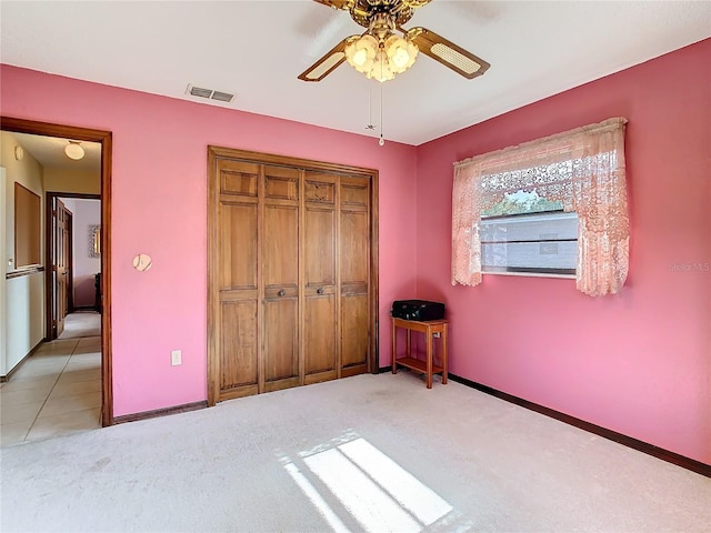 unfurnished bedroom with light colored carpet, a closet, and ceiling fan