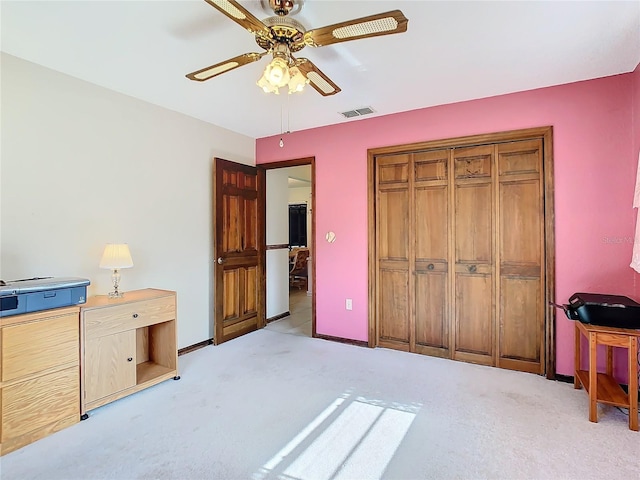 bedroom featuring light carpet, a closet, and ceiling fan