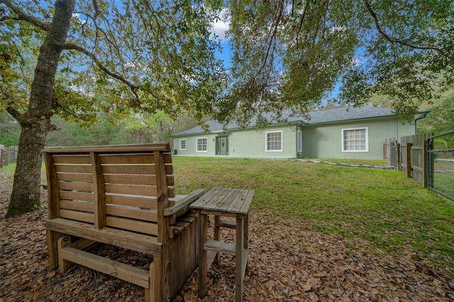 rear view of house featuring a lawn