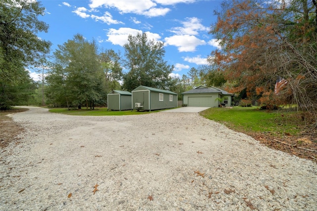 view of front facade with a storage shed, a garage, and a front lawn