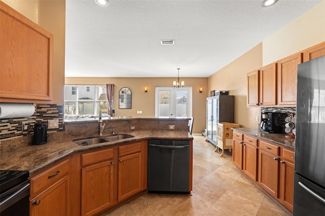 kitchen featuring sink, stainless steel refrigerator, dishwashing machine, pendant lighting, and backsplash