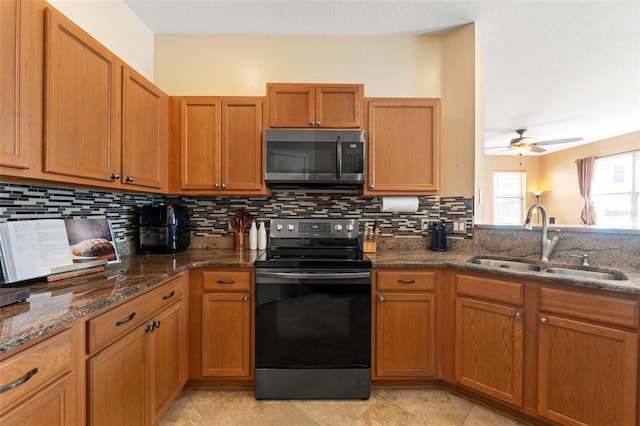 kitchen with sink, range with electric stovetop, ceiling fan, dark stone counters, and decorative backsplash