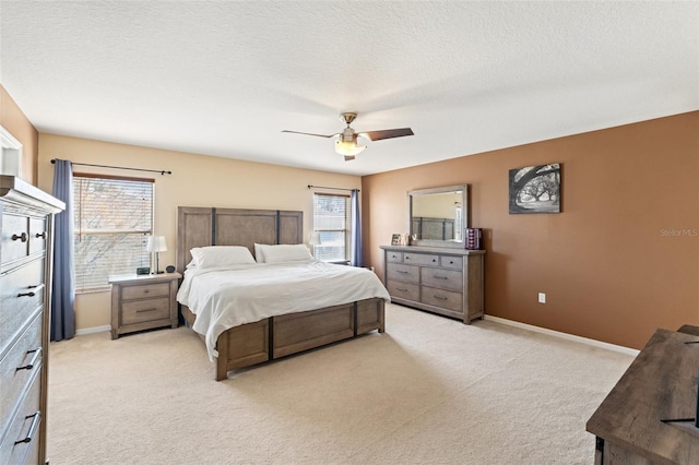 carpeted bedroom featuring ceiling fan and a textured ceiling