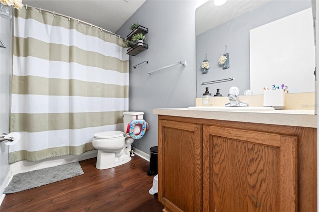 bathroom with vanity, hardwood / wood-style floors, walk in shower, and toilet