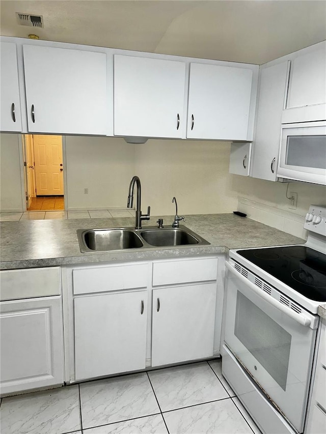 kitchen with white cabinetry, white appliances, and sink