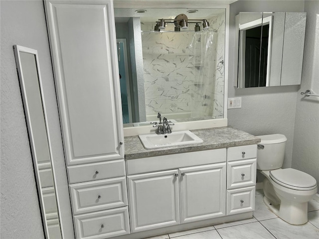 bathroom with vanity, toilet, and a tile shower