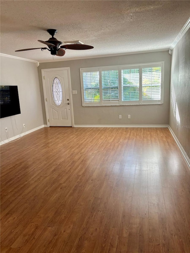 foyer entrance featuring ceiling fan, crown molding, wood-type flooring, and a textured ceiling