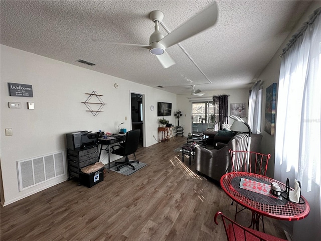 interior space featuring hardwood / wood-style flooring, ceiling fan, and a textured ceiling